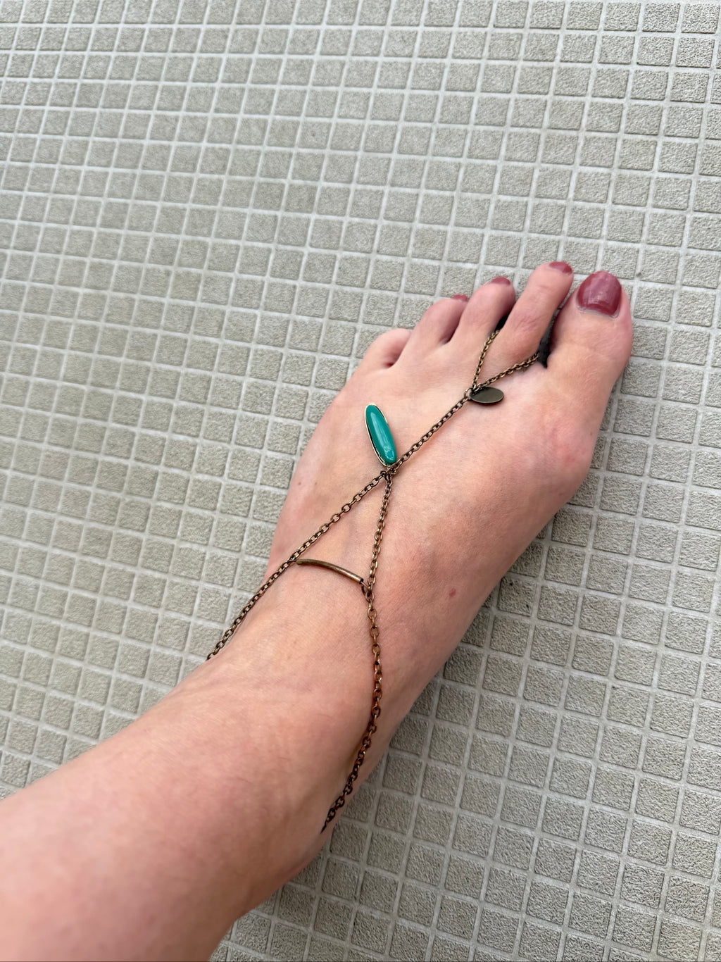 Festival foot chain jewelry in worn bronze with turquoise and green stones, artisan design.