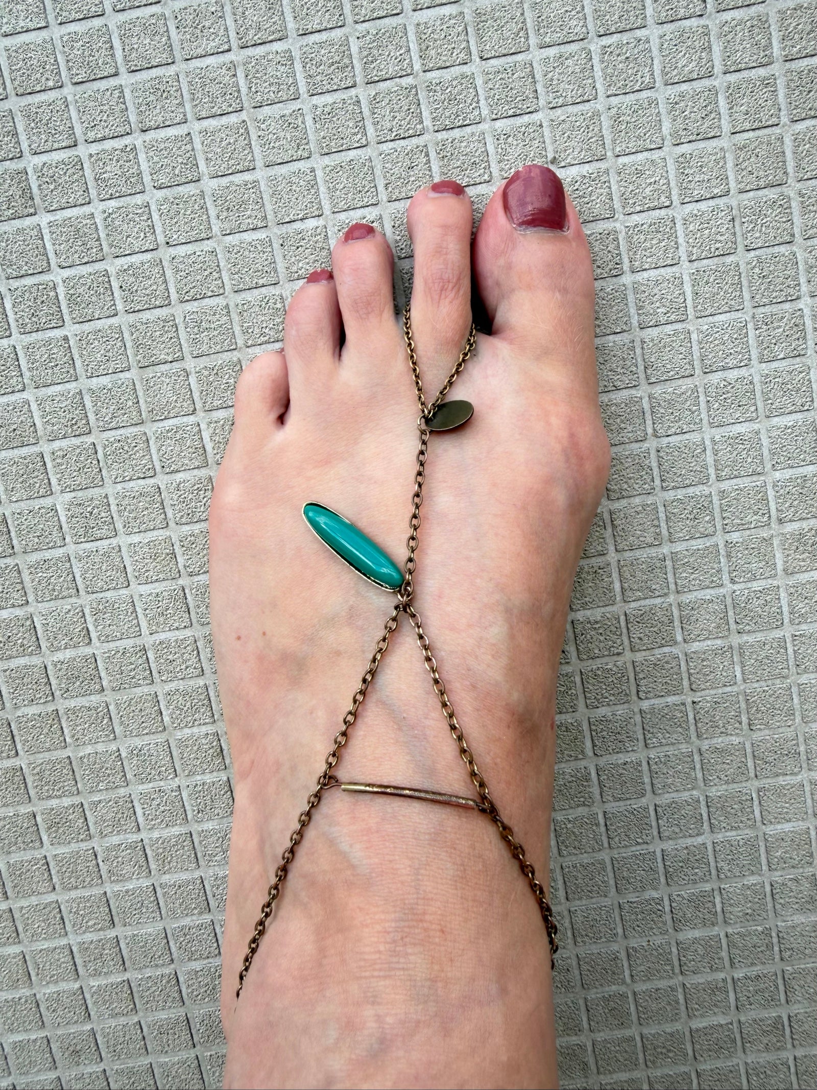 Festival foot chain jewelry in worn bronze with turquoise and green stones, artisan design.