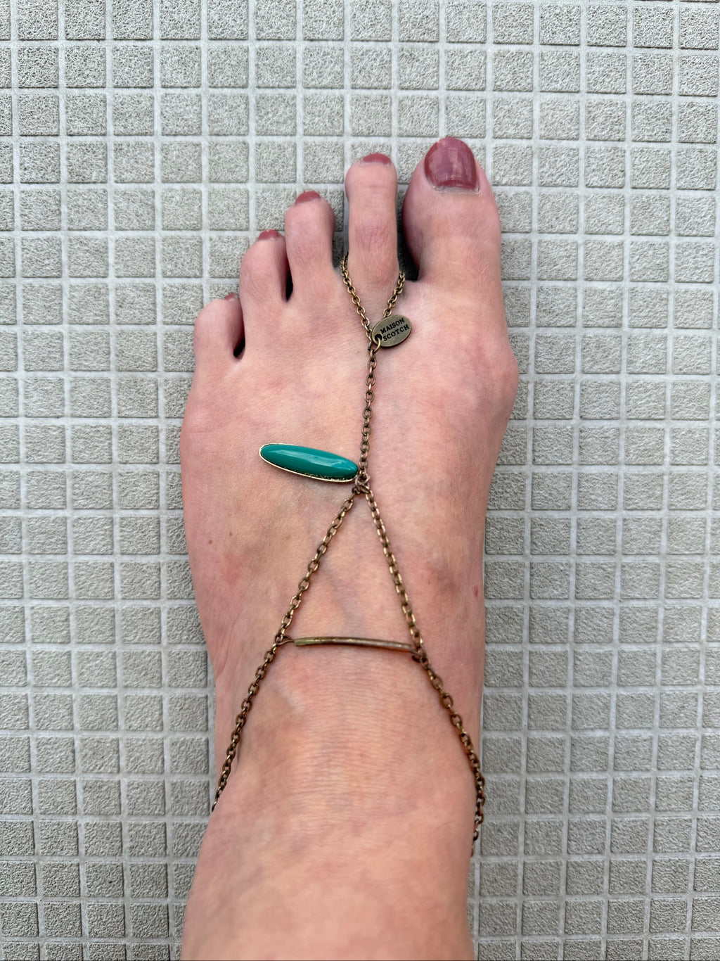 Festival foot chain jewelry in worn bronze with turquoise and green stones, artisan design.
