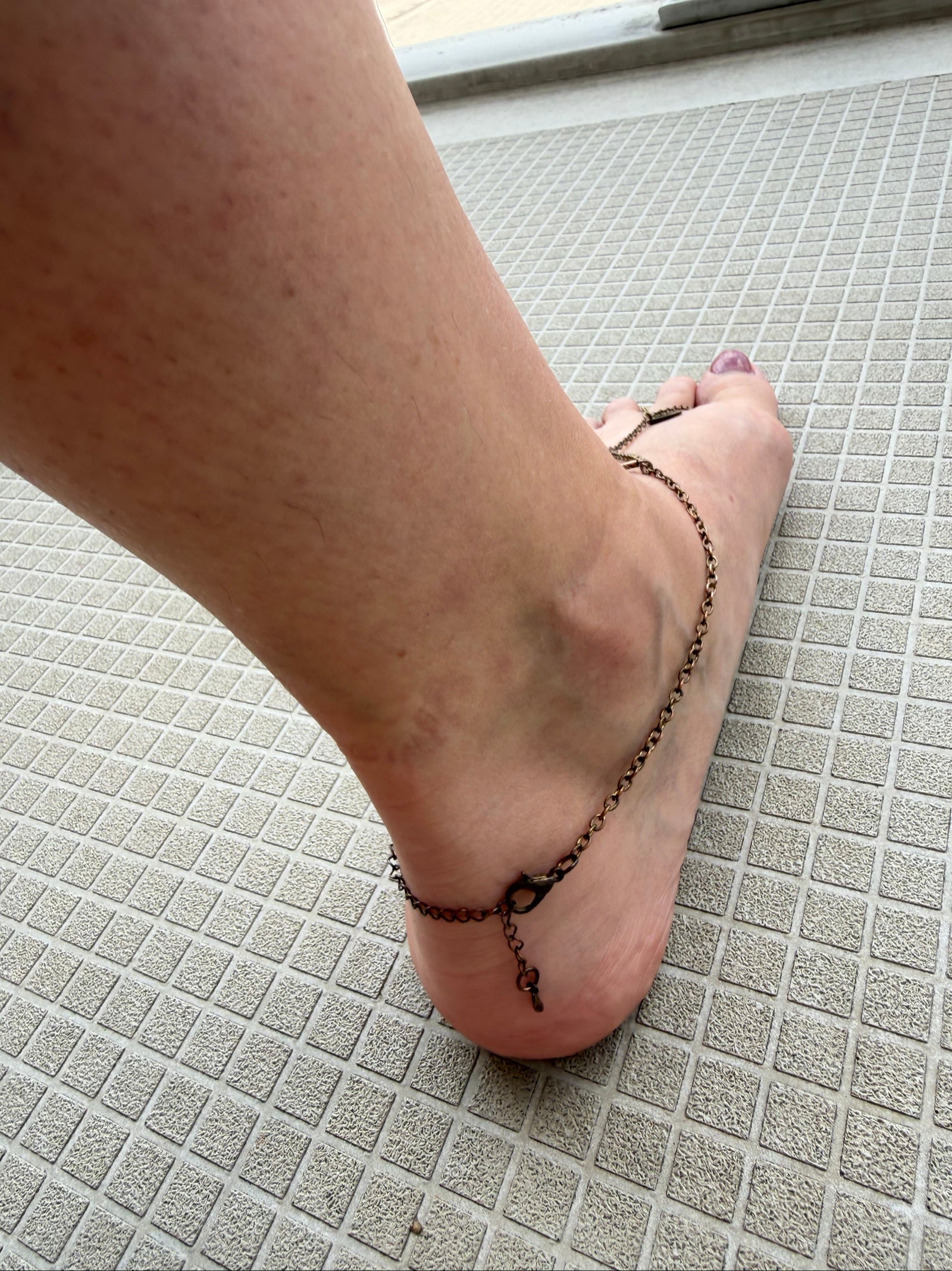 Festival foot chain jewelry in worn bronze with turquoise and green stones, artisan design.