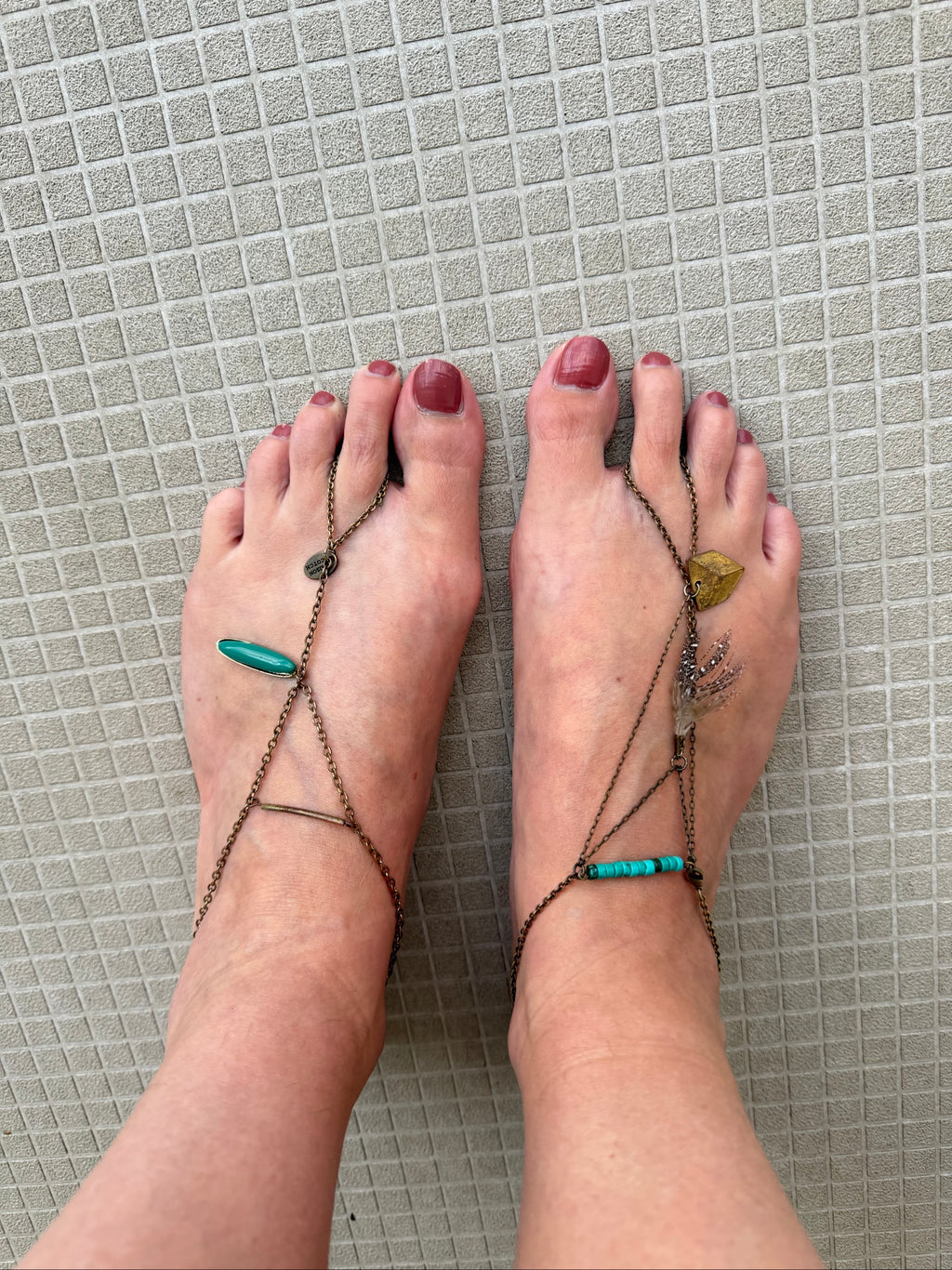 Festival foot chain jewelry in worn bronze with turquoise and green stones, artisan design.